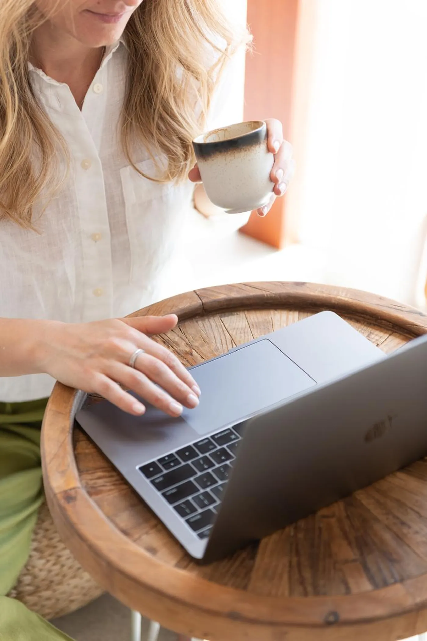 Iuliana at her desk with a cup of tea and her laptop open