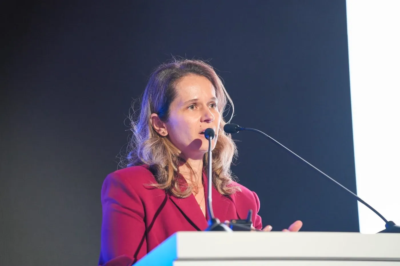 Iuliana speaking at a conference lectern