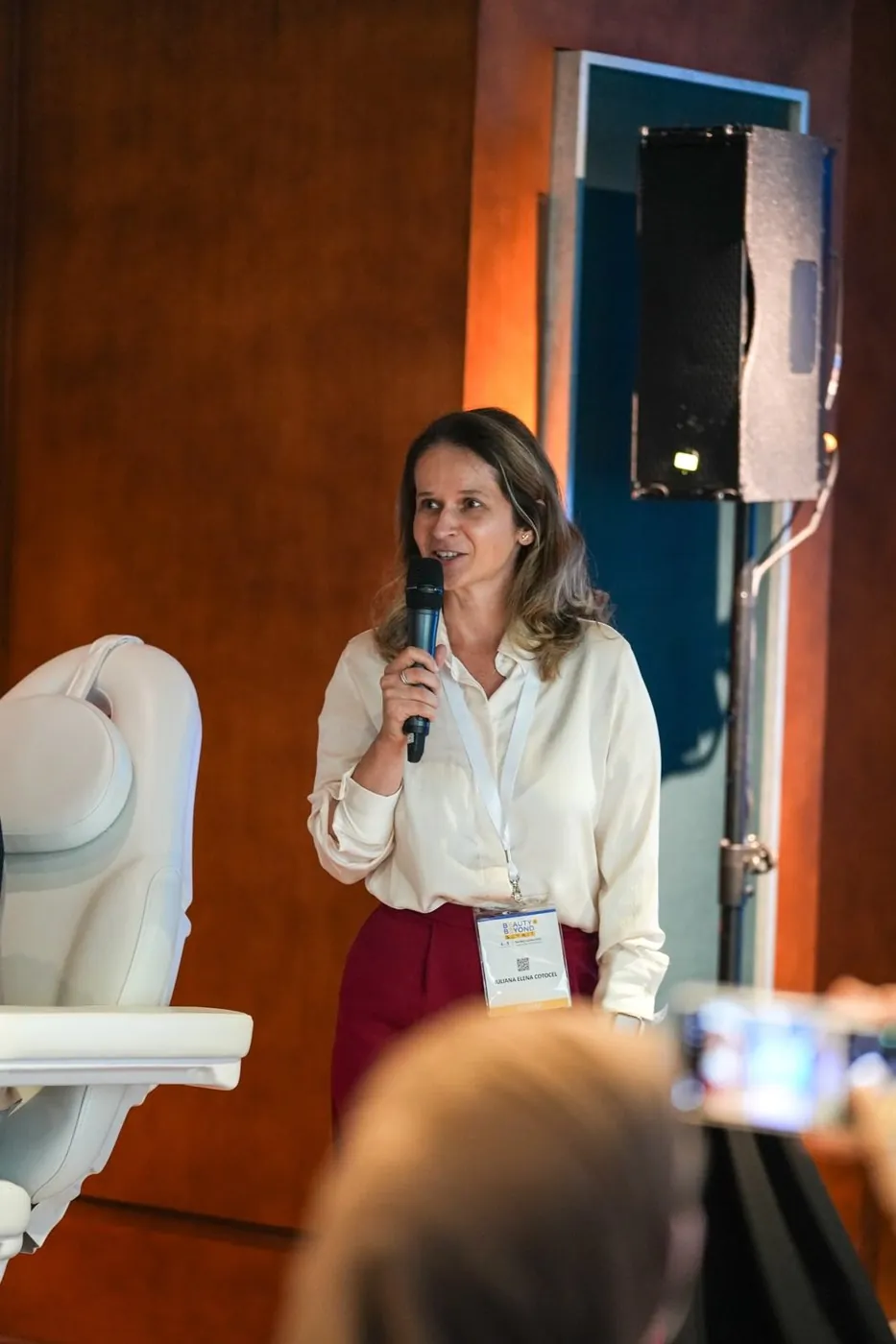 Iuliana with a microphone, speaking to an audience