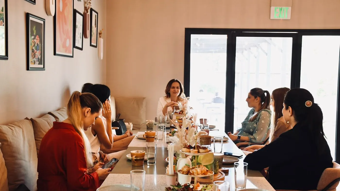 Iuliana hosting a workshop around a table of women